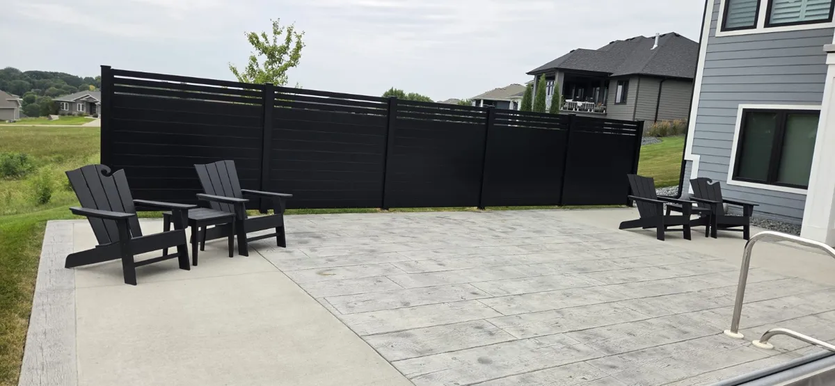 Black horizontal fence alongside a finished patio